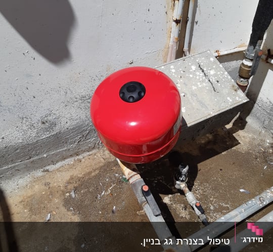מיכל לחץ אדום וצינורות מתכת עם ברזים